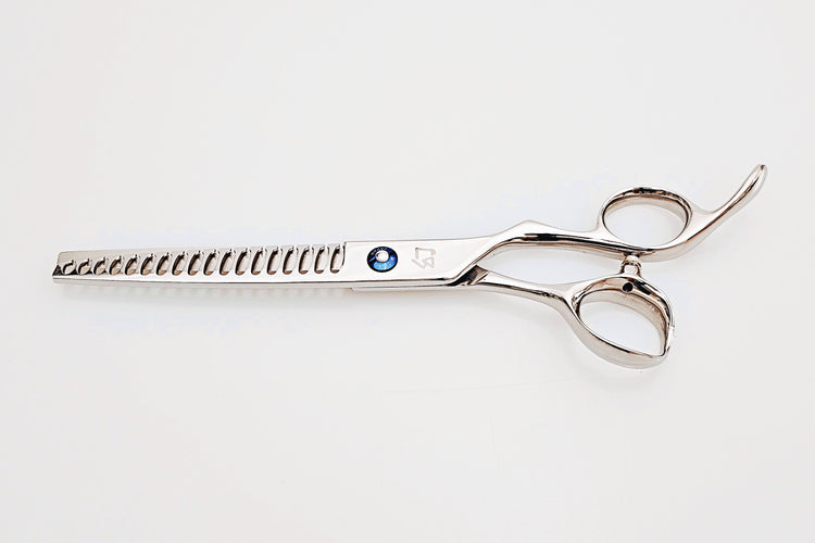 Barber texturizing shears on a white surface.