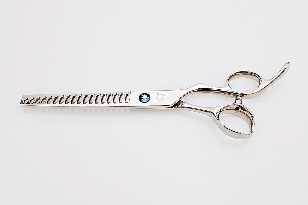 Barber texturizing shears on a white surface.