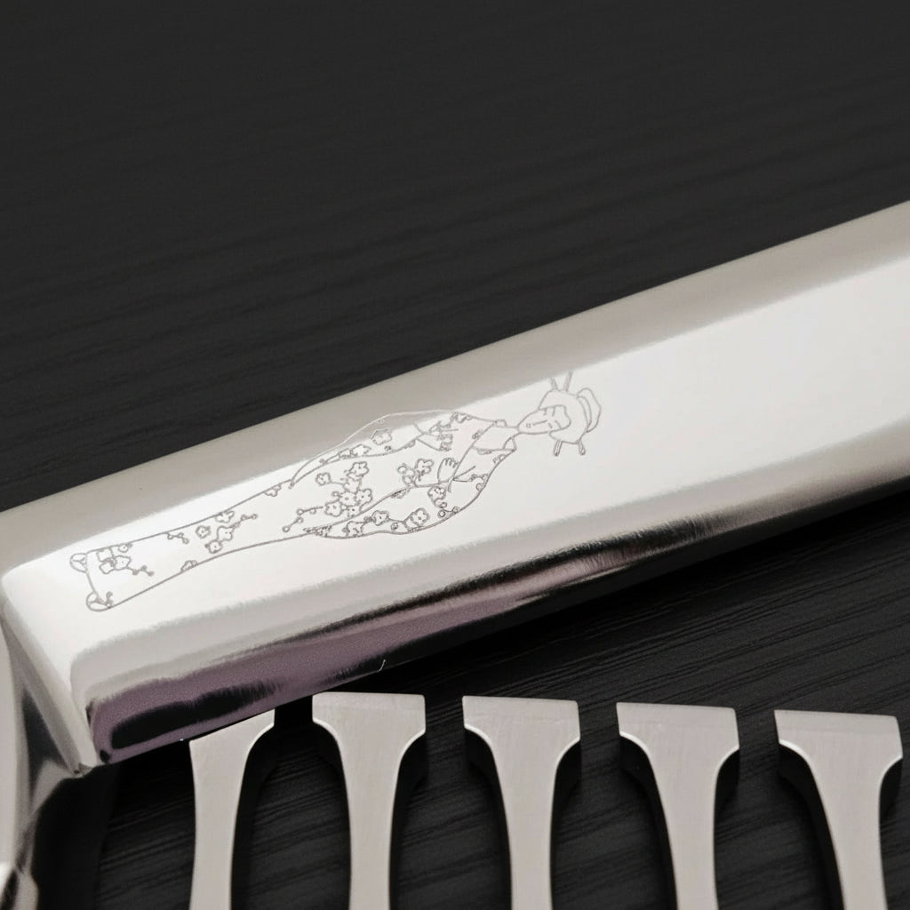 Close-up of hair texturizer blade with engraved Japanese lady logo on a black background