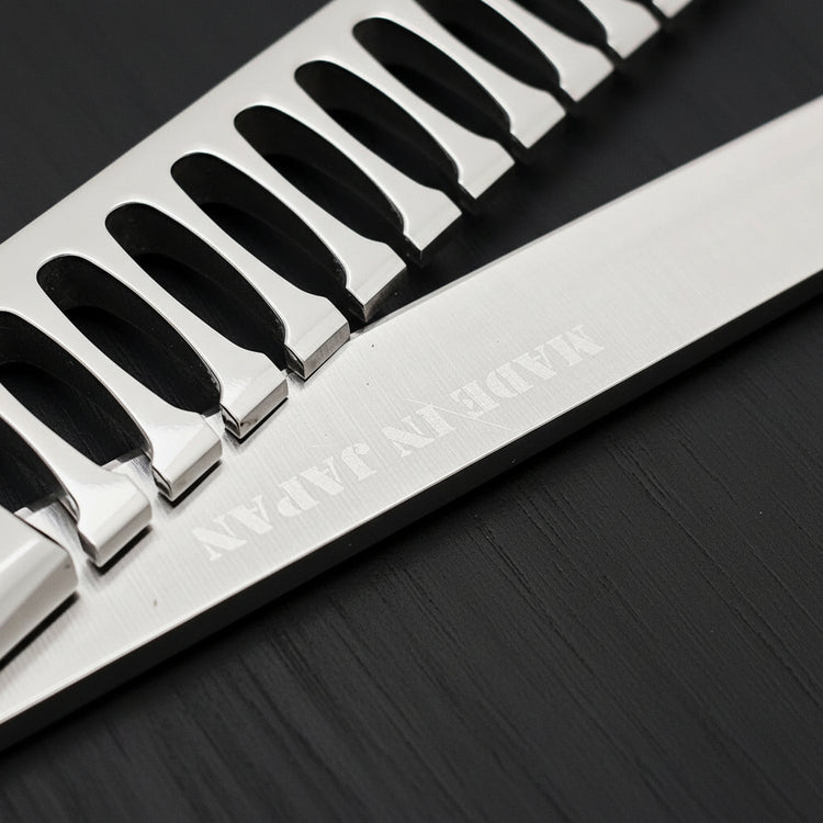 Close-up of hair texturizing shears with engraved 'Made in Japan' text on a black background