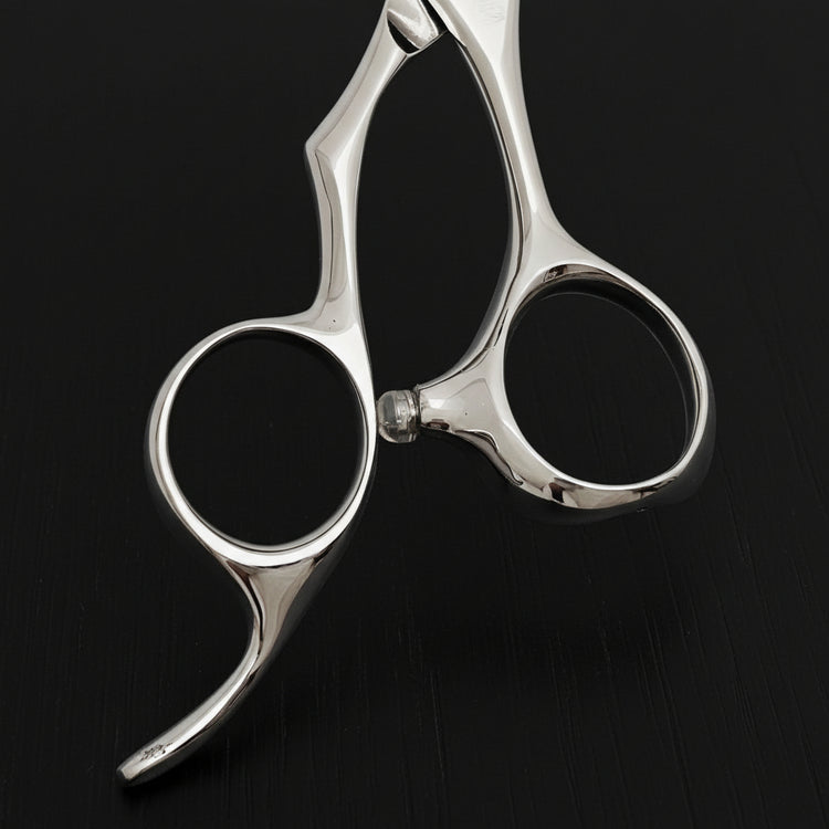 Close-up of a pair of silver hair scissors handle part on a black background
