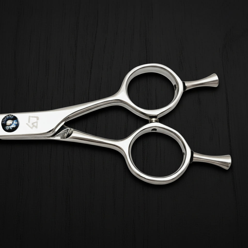 Close-up of hair cutting shears handle on a black background