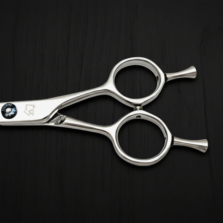Close-up of hair cutting shears handle on a black background