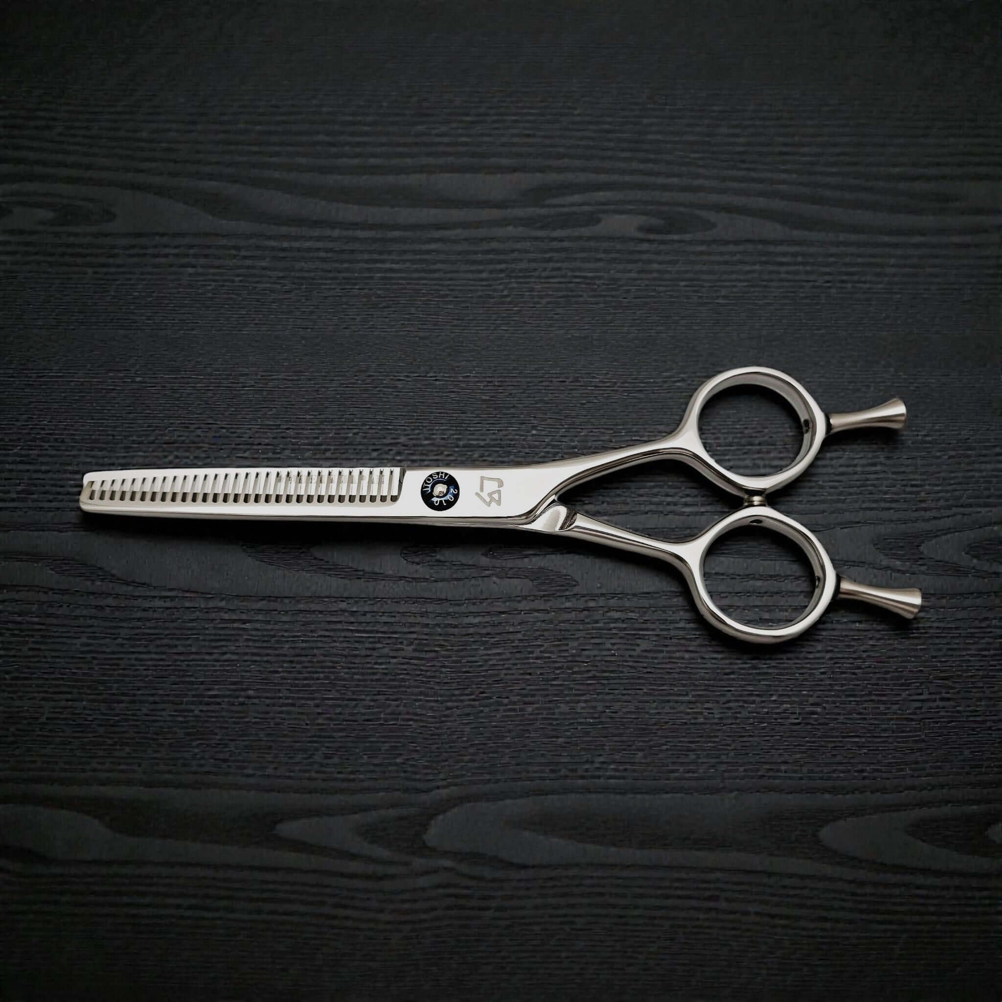 Hair thinning scissors on a dark wooden surface