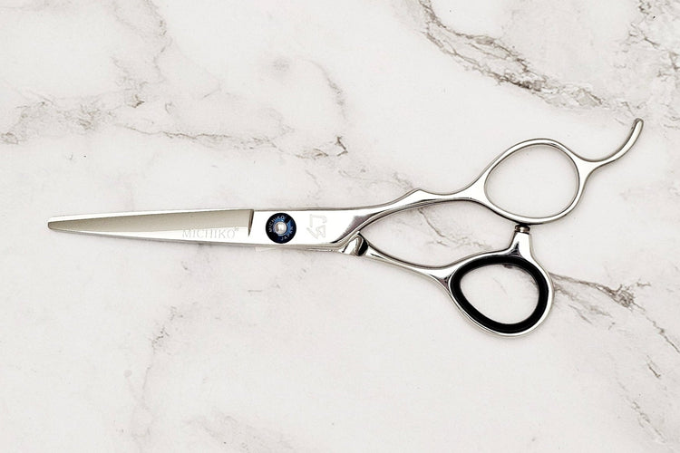 AI 5.5 Hair scissors on a white marble background.