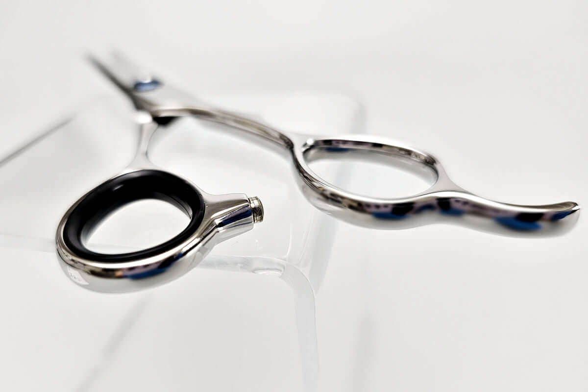 Close-up of hair cutting shears' handle on a white background.