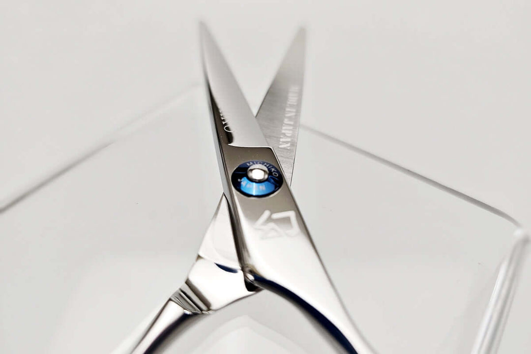 Close-up of a pair of hair scissors with a MICHIKO brand name on a white background