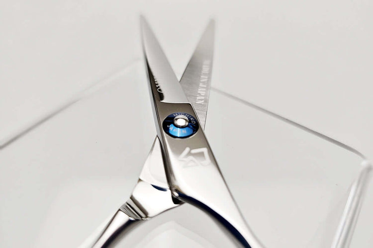 Close-up of a pair of hair scissors with a MICHIKO brand name on a white background
