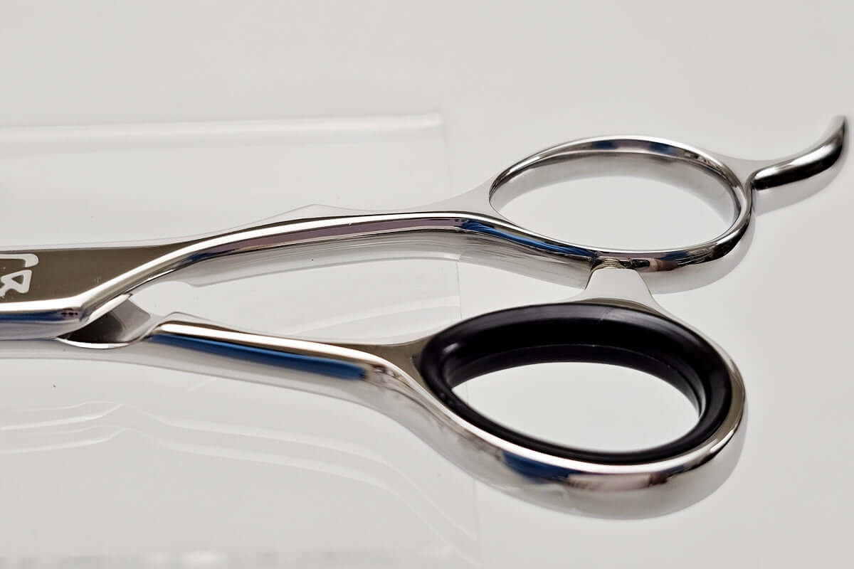Close-up of hair scissors handle on a light gray background