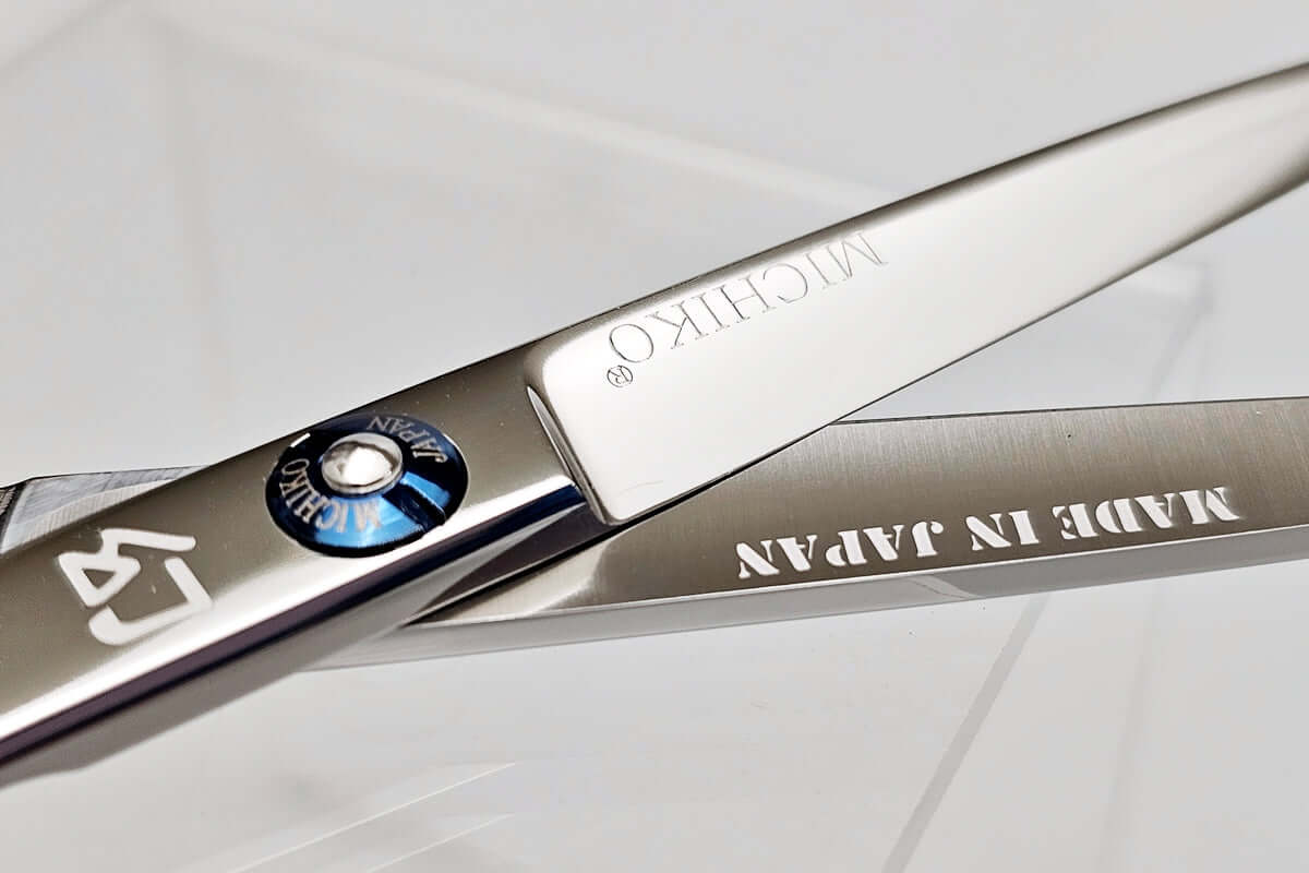 Close-up of a pair of hair scissors with 'MICHIKO' branding on a white background