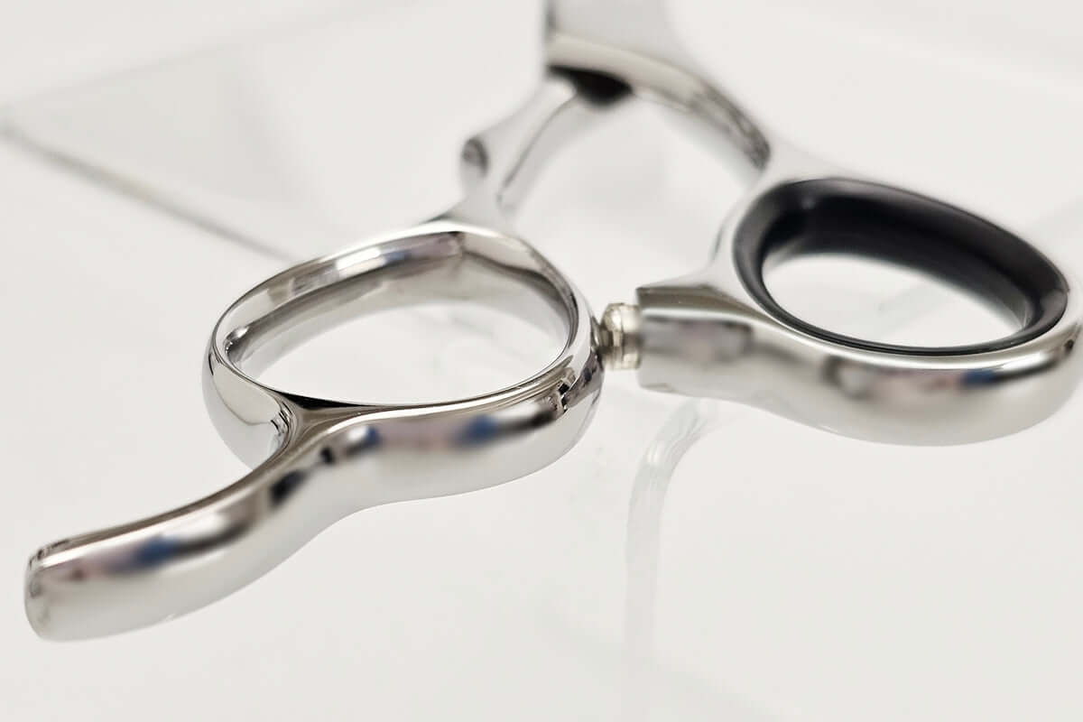 Close-up of hair scissors handle on a white background