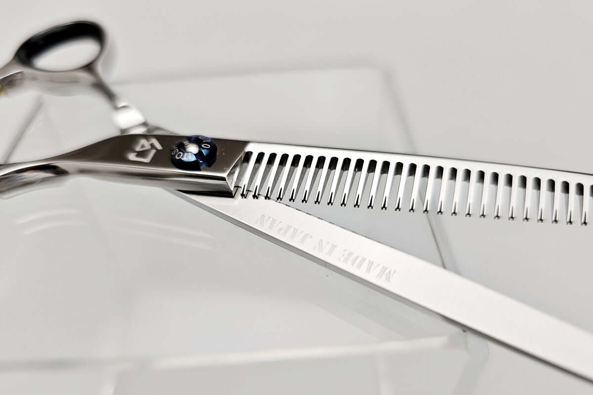  Open position of hair thinning scissors showing details of each teeth on a white background