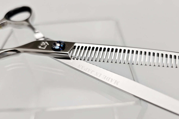  Open position of hair thinning scissors showing details of each teeth on a white background