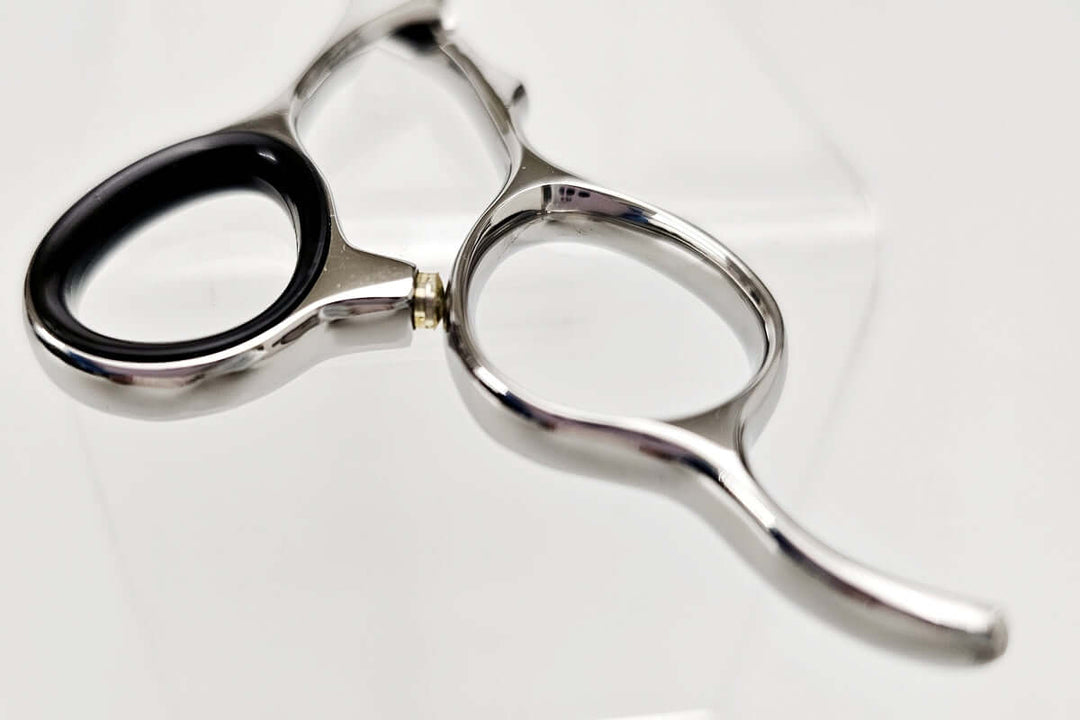 Close-up of a handle part of hair scissors on a white background