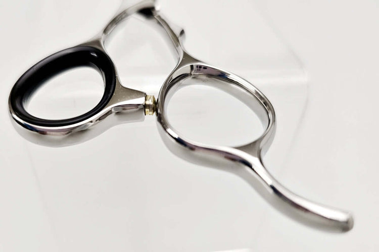 Close-up of a handle part of hair scissors on a white background