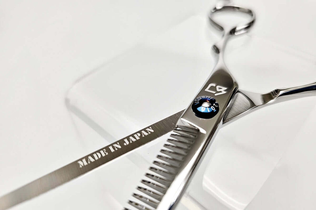 Open position of hair thinning scissors with 'Made in Japan' engraving on a white background