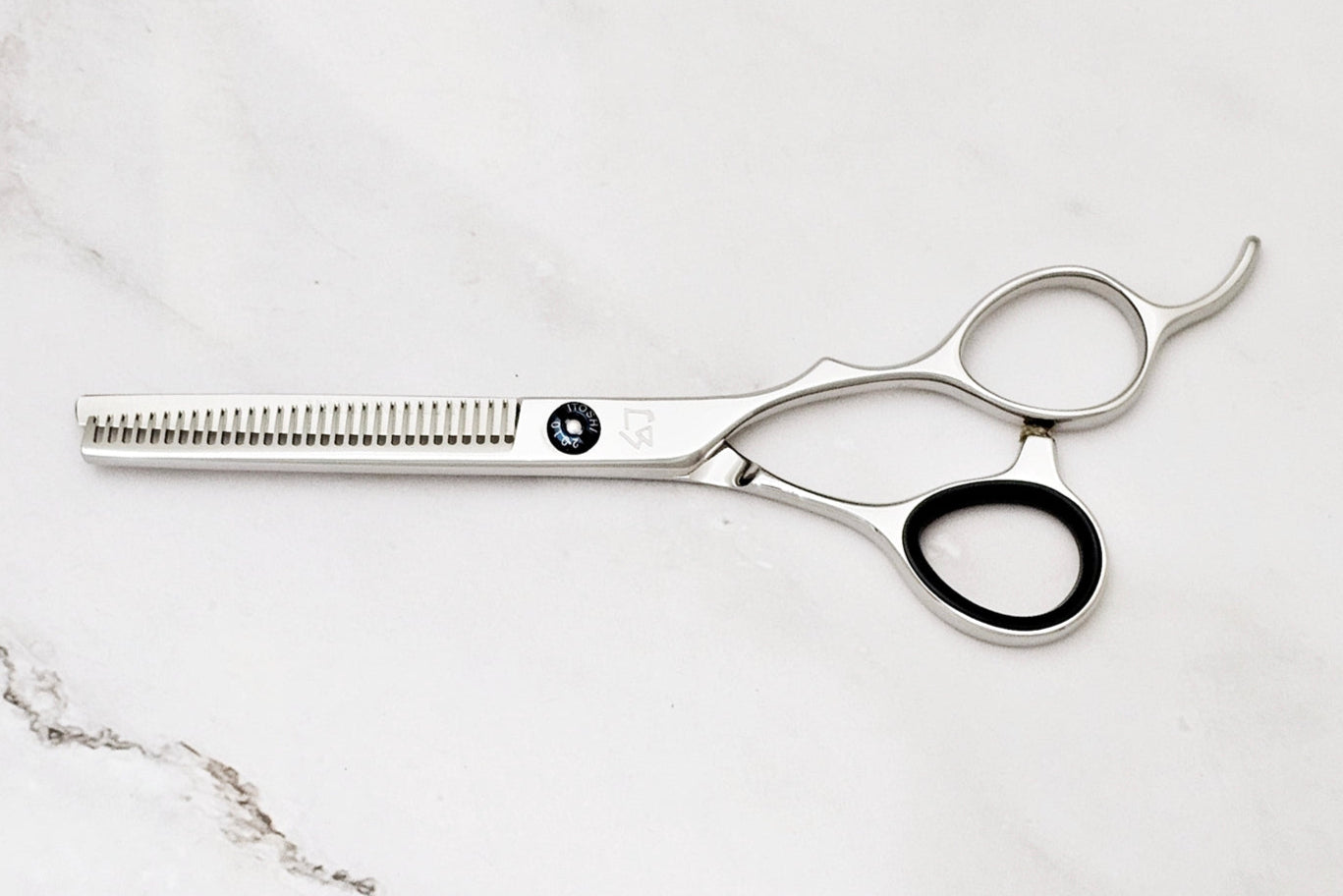 Hair cutting scissors on a marble surface