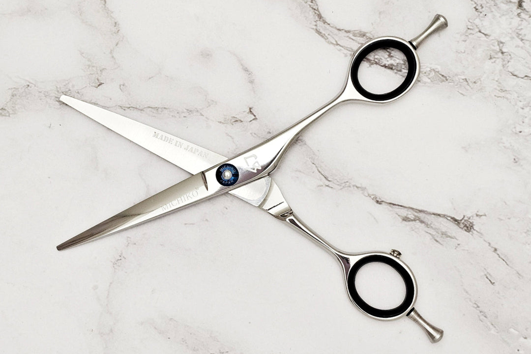 Pair of hair scissors on a marble surface