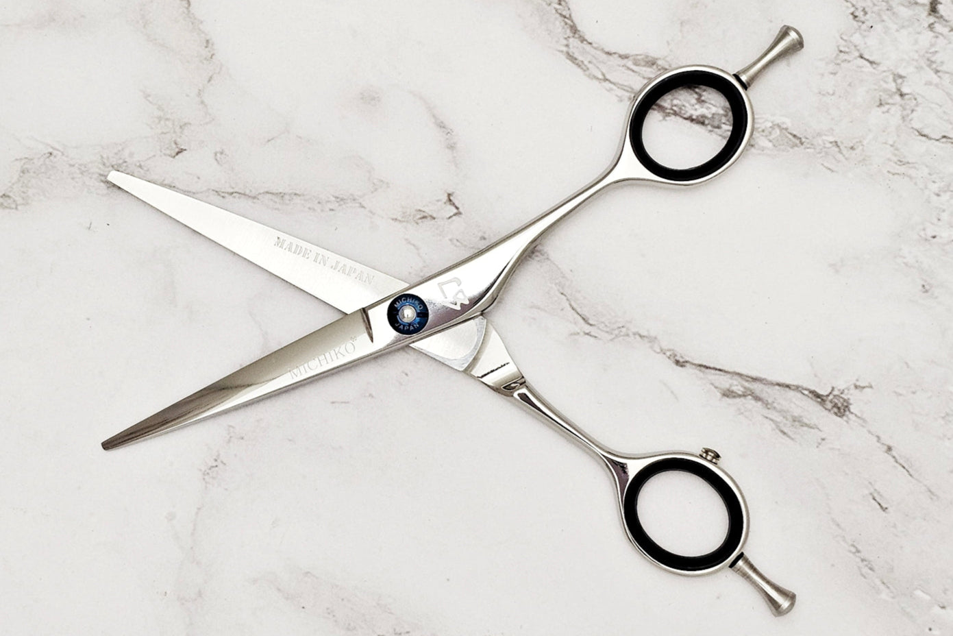 Pair of hair scissors on a marble surface