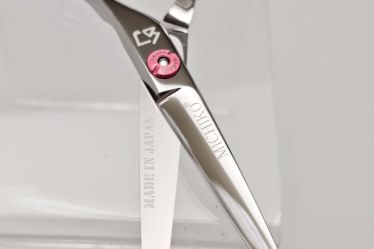 Close-up of a pair of hair scissors with the MICHIKO brand logo on a white background