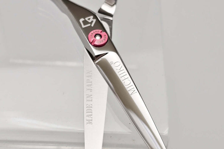Close-up of a pair of hair scissors with the MICHIKO brand logo on a white background