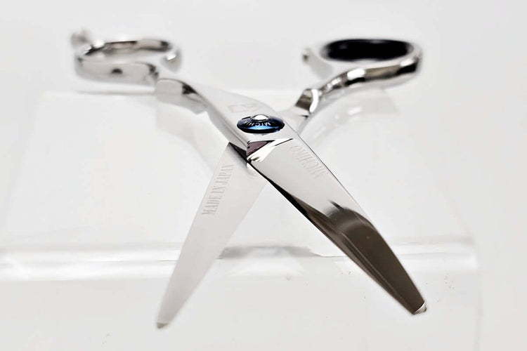 Silver hair scissors with a blue screw design on a white background