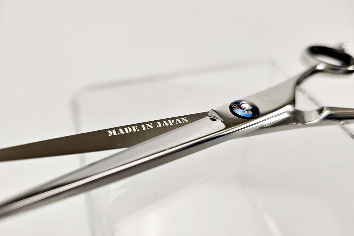Pair of hair scissors with 'Made in Japan' engraving on a white background