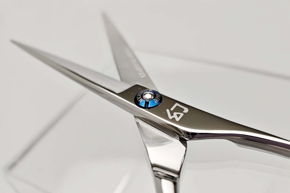 Close-up of a pair of hair scissors with a MICHIKO brand logo on a white background