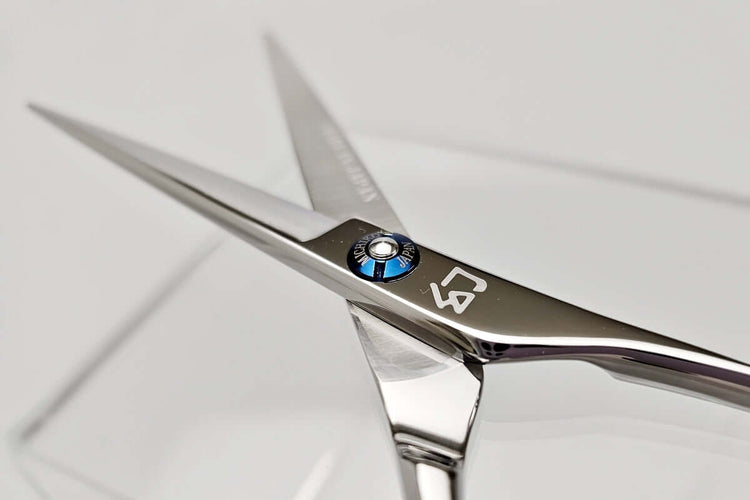 Close-up of a pair of hair scissors with a MICHIKO brand logo on a white background