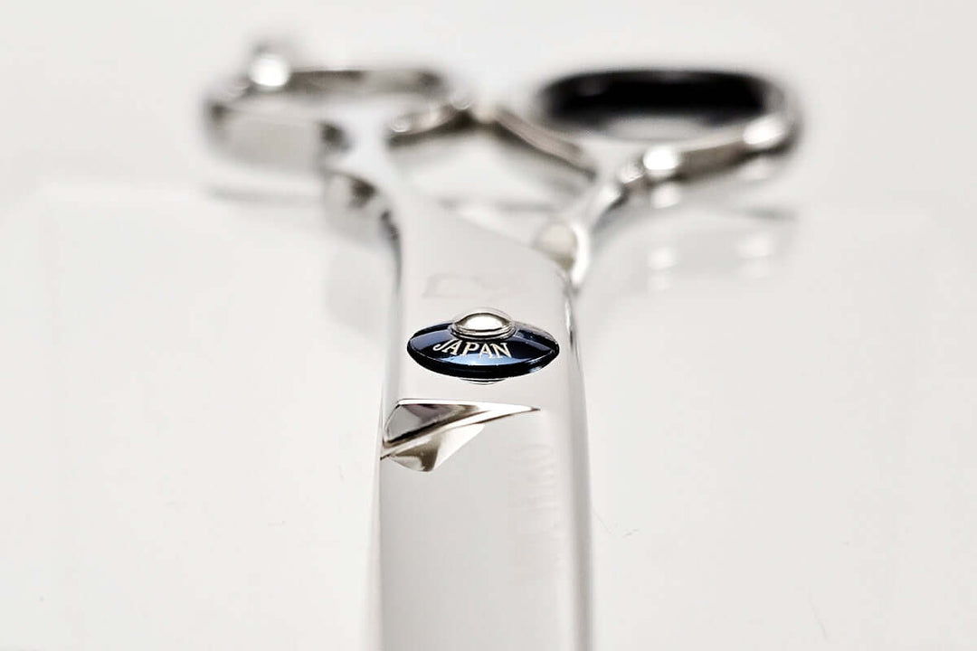 Close-up of hair scissors with 'Japan' engraving on a white background