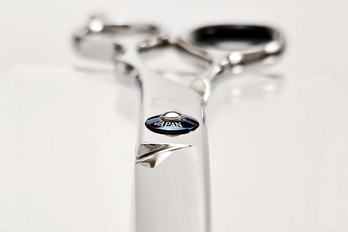 Close-up of hair scissors with 'Japan' engraving on a white background