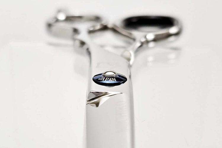 Close-up of hair scissors with 'Japan' engraving on a white background