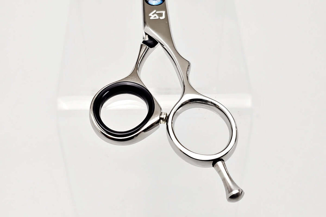 Close-up of hair-cutting scissors handle on a white background