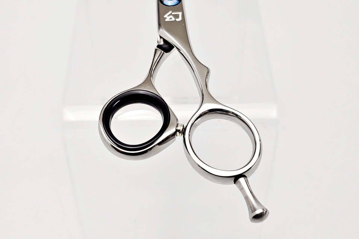 Close-up of hair-cutting scissors handle on a white background