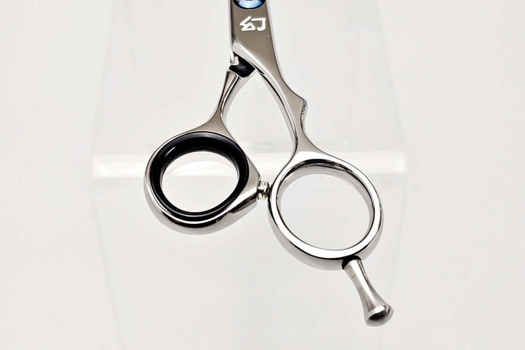 Close-up of hair-cutting scissors handle on a white background