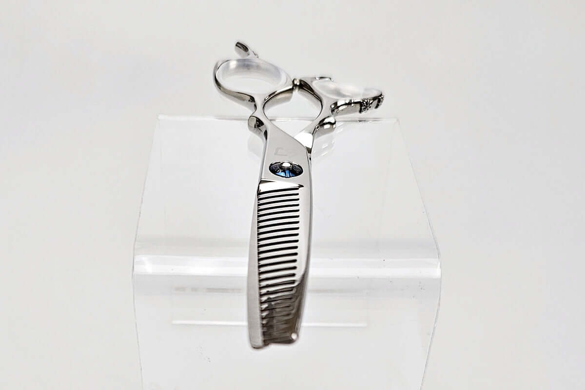 Hair thinning shears on a clear stand against a white background