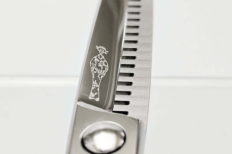 Close-up of a pair of thinning scissors with a logo on a white background