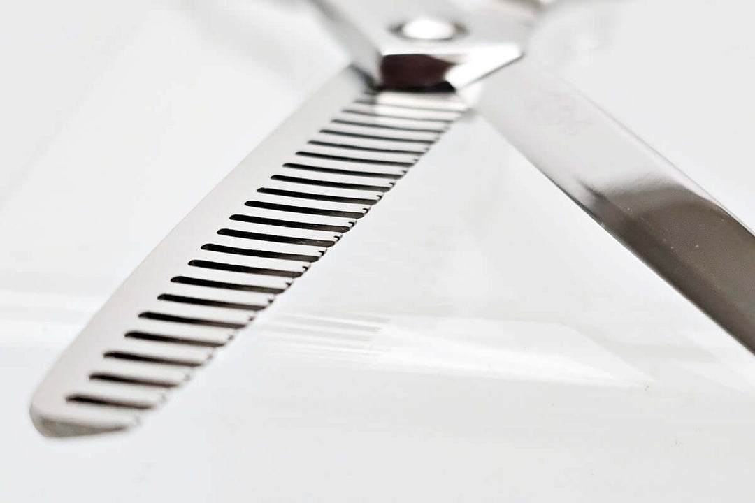 Close-up of hair thinning scissors theeth part on a white background