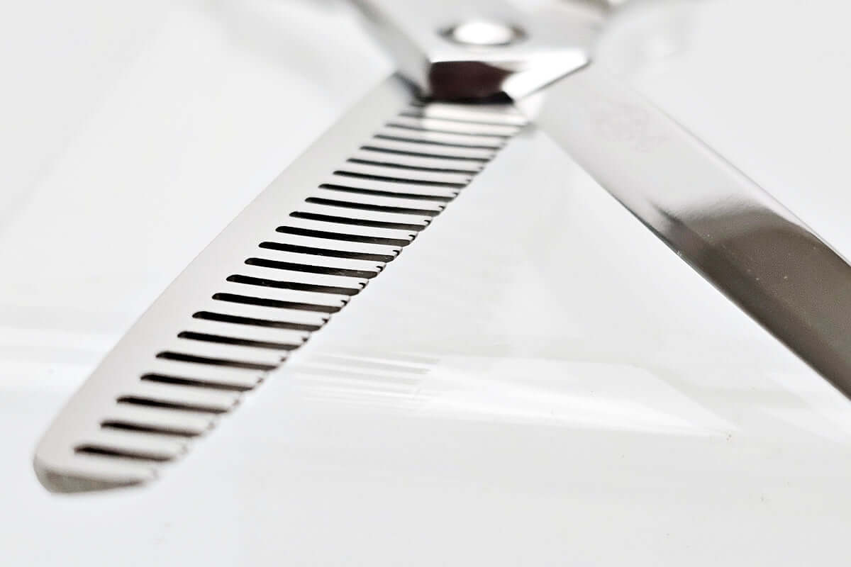 Close-up of hair thinning scissors theeth part on a white background
