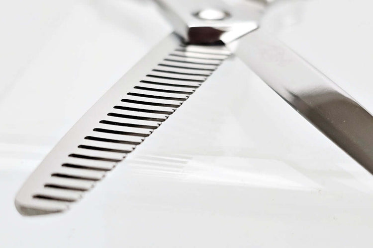 Close-up of hair thinning scissors theeth part on a white background