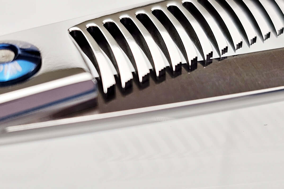 Close-up of hair thinning scissors teeth part on a light gray background
