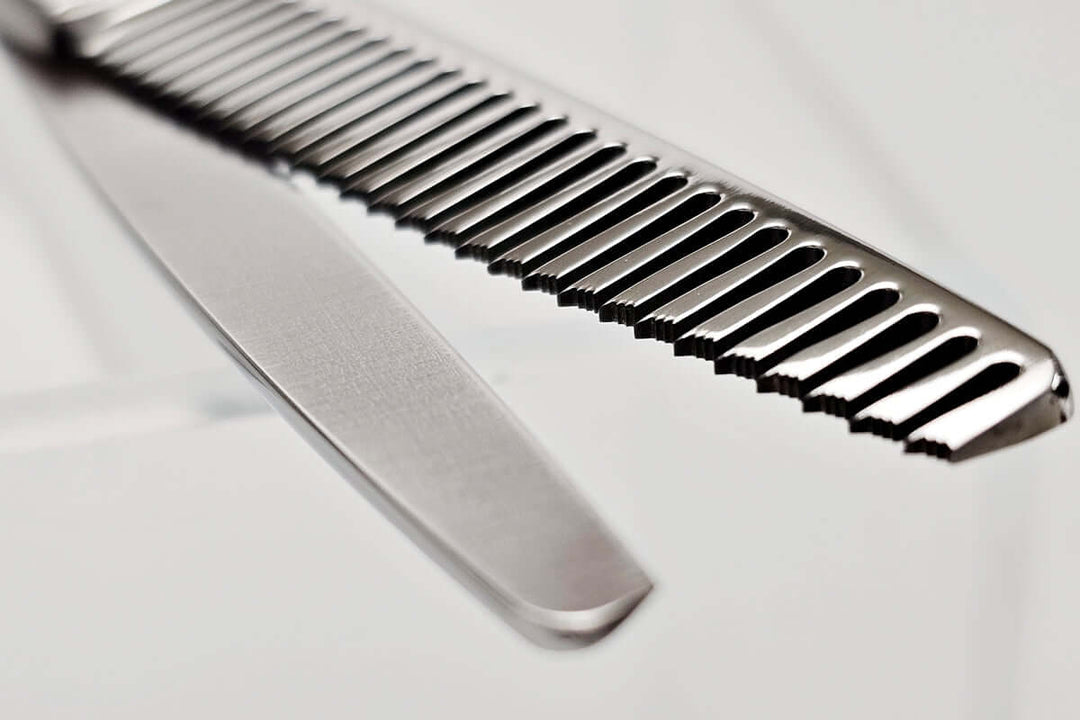 Close-up of hair thinning scissors teeth part on a light gray background