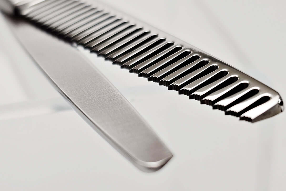 Close-up of hair thinning scissors teeth part on a light gray background