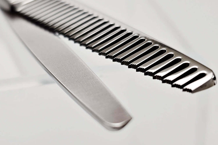 Close-up of hair thinning scissors teeth part on a light gray background