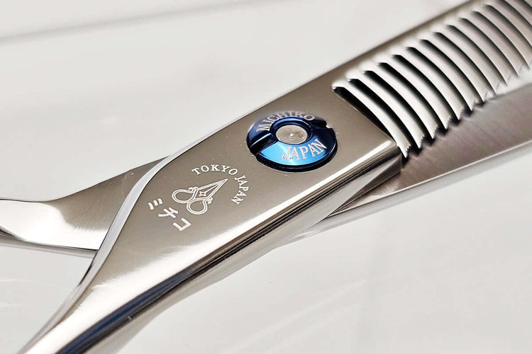 Close-up of hair thinning scissors teeth part on a light gray background