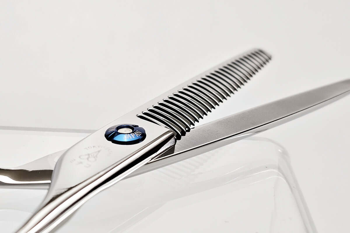 Close-up of hair thinning scissors on a light gray background
