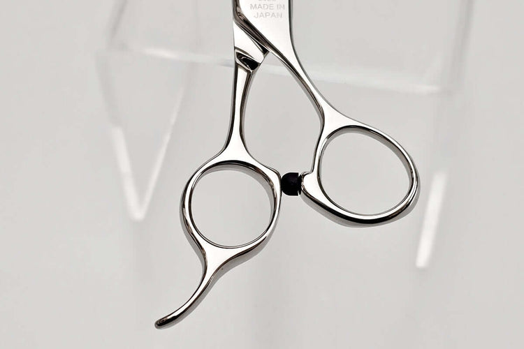 Close-up of hair cutting shears handle part on a light gray background