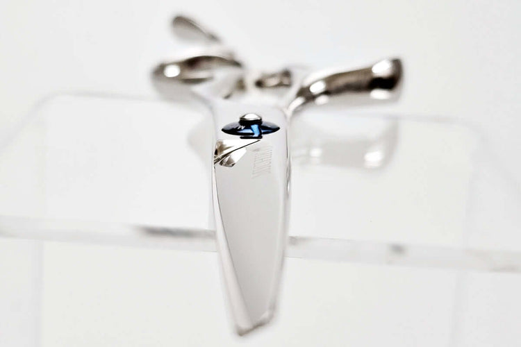 Hair scissors with a blue screw on a light gray background