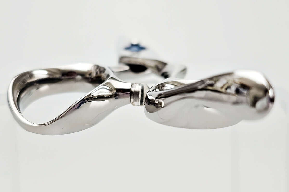 Hair scissors with a blue screw on a white background