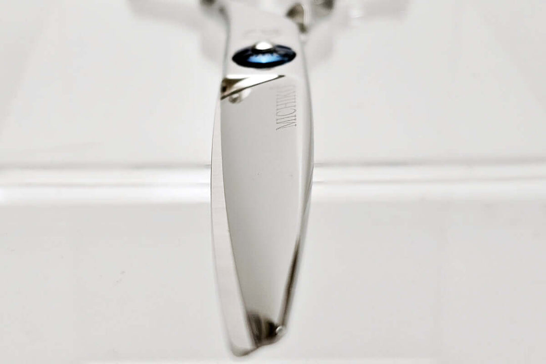 Close-up of a hair scissors blade on a white background